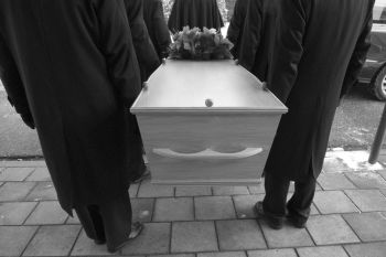 men wearing black and carrying a white casket