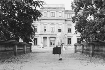 old man as henry gatz walking towards mansion